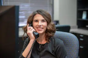 Dental assistant at our Garland dental office talking to a new patient on the phone to schedule his appointment.