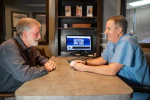 Our Garland dentist, Dr. Scott Dooley, with a patient talking about dental implants for seniors