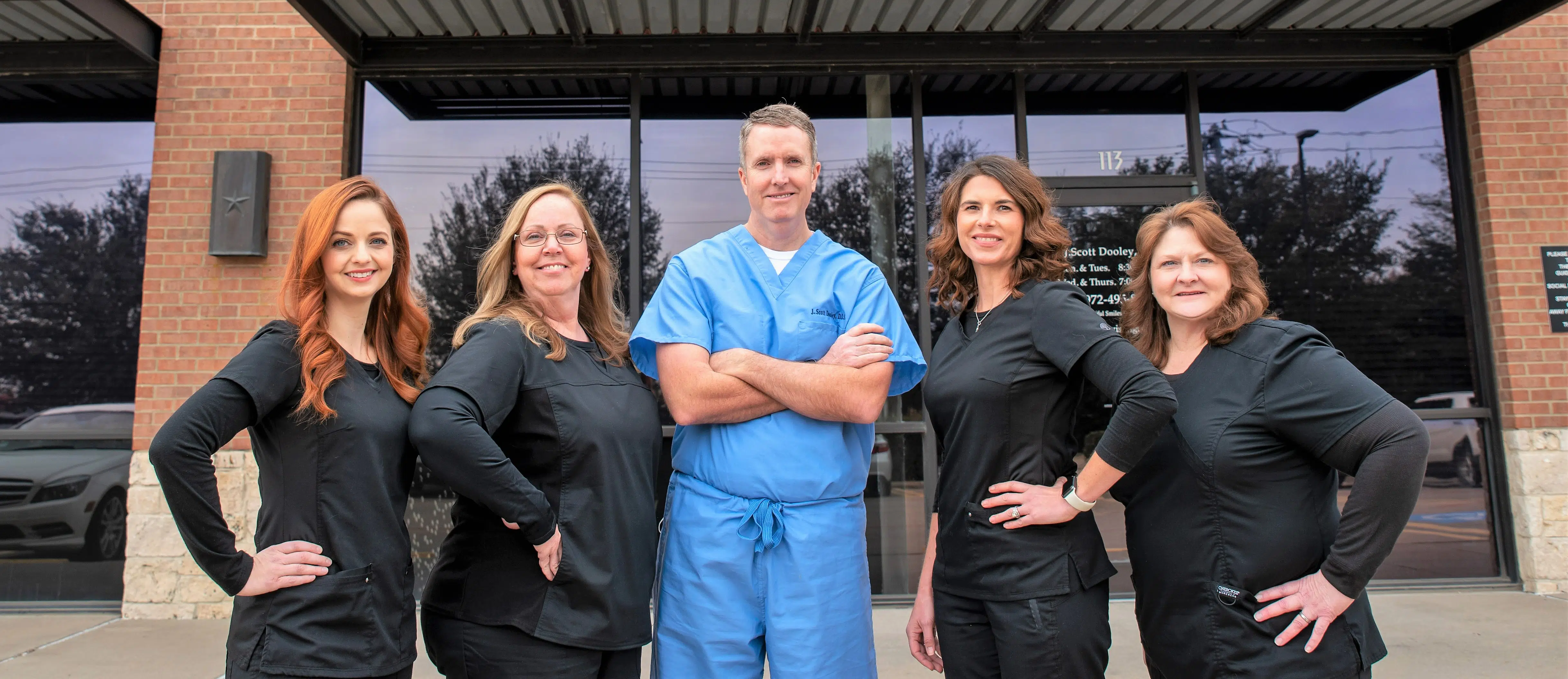 Our Garland dental team smiling for a picture with Dr. Scott Dooley, dentist in Garland, in the middle.